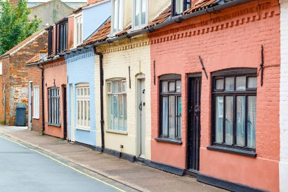 A row of colourful English holiday homes for leisure travellers in a seaside town on a sunny day